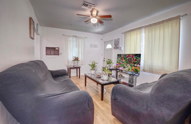 living room with ceiling fan and light hardwood / wood-style flooring