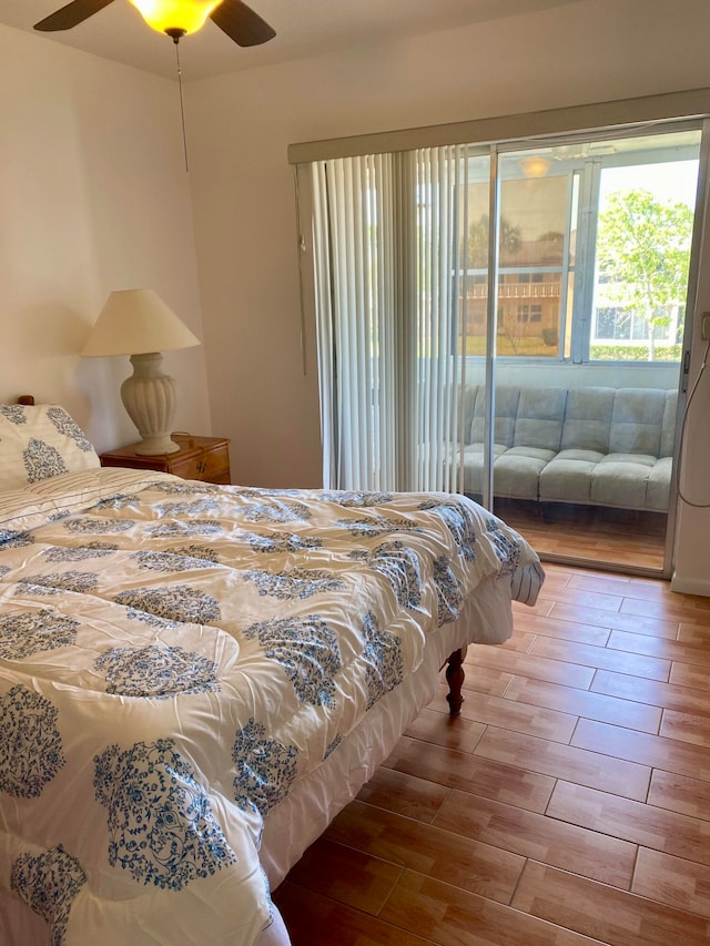 bedroom featuring access to outside, hardwood / wood-style floors, and ceiling fan