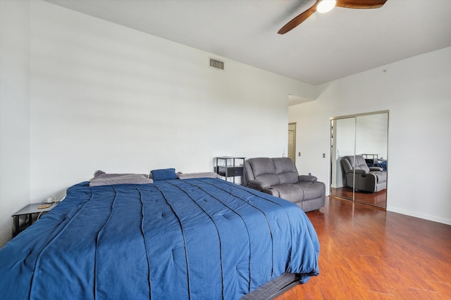 bedroom with dark hardwood / wood-style flooring, ceiling fan, and a closet