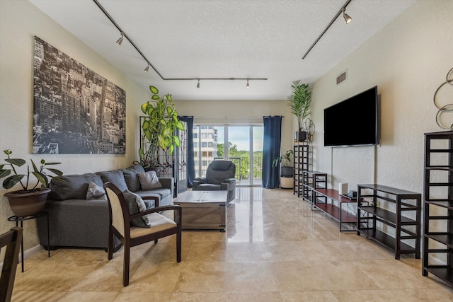 living room featuring rail lighting and a textured ceiling