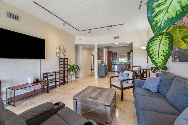 tiled living room featuring rail lighting