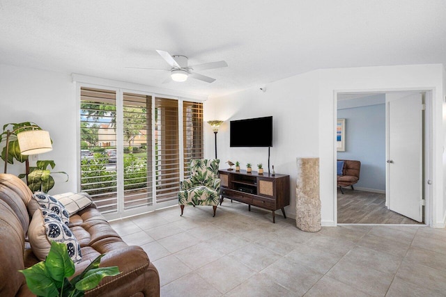 living room featuring ceiling fan, a textured ceiling, and light tile patterned floors