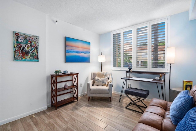 sitting room with a textured ceiling and light wood-type flooring