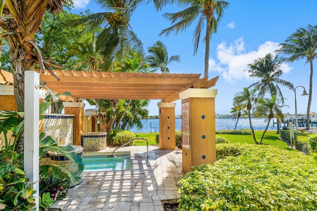 view of swimming pool featuring a yard, a pergola, a water view, and a patio area