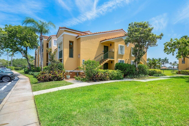 mediterranean / spanish-style house featuring a balcony and a front lawn