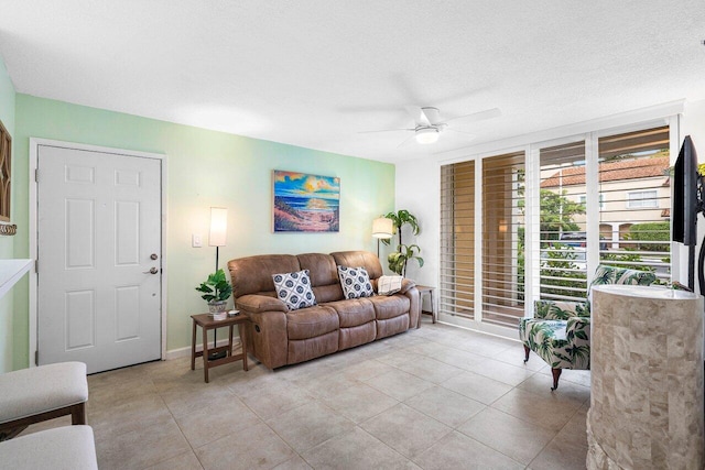 living room with ceiling fan and a textured ceiling