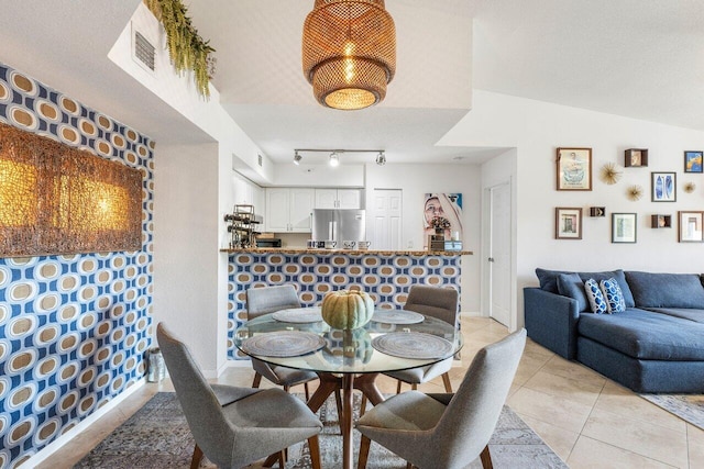 dining room featuring light tile patterned floors and lofted ceiling