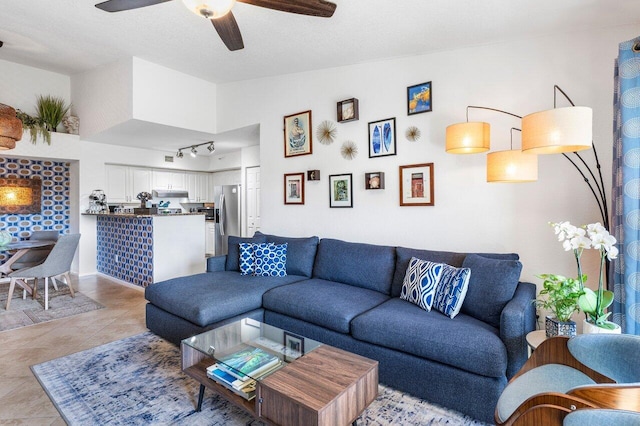 tiled living room with rail lighting and ceiling fan