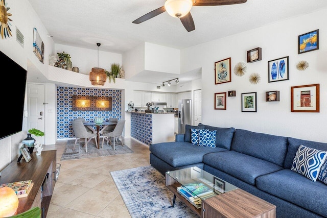 living room with light tile patterned floors, a textured ceiling, and a high ceiling