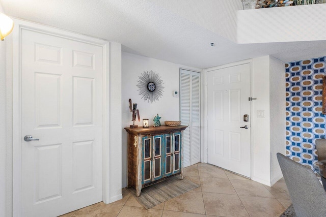 entryway featuring light tile patterned floors and a textured ceiling