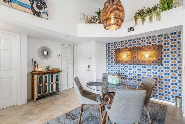 tiled dining space featuring a towering ceiling