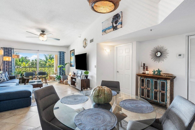 living room with ceiling fan, light tile patterned floors, and a textured ceiling