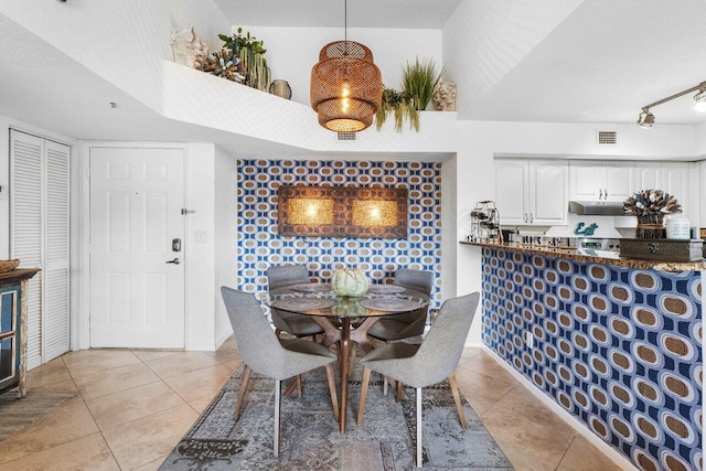 dining space with light tile patterned floors and a textured ceiling