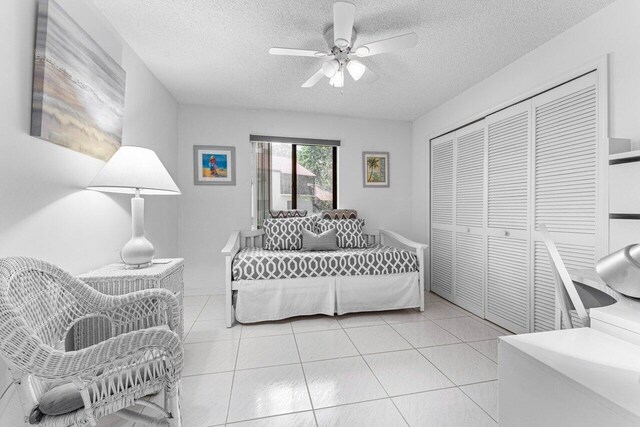 10 Via De Casas Sur Unit 104, Boynton Beach, FL 33426 - bedroom featuring a textured ceiling, a closet, light tile patterned flooring, and ceiling fan