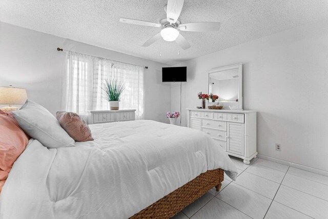 tiled bedroom with a textured ceiling and ceiling fan