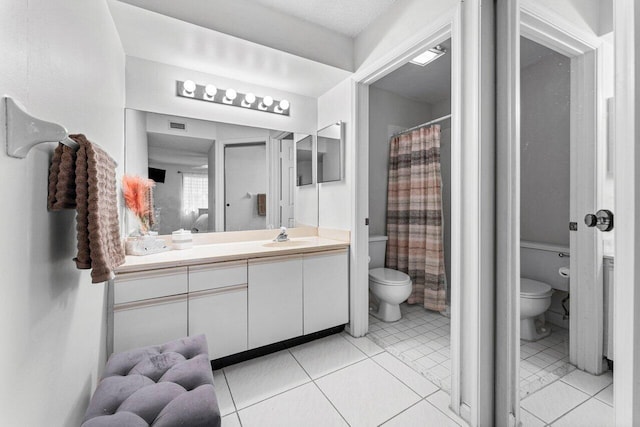 bathroom featuring tile patterned flooring, vanity, and toilet