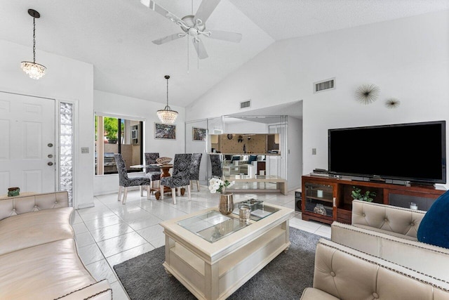 living room featuring a textured ceiling, ceiling fan with notable chandelier, light tile patterned flooring, and high vaulted ceiling