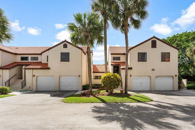 10 Via De Casas Sur Unit 104, Boynton Beach, FL 33426 - mediterranean / spanish home with an attached garage, a tiled roof, stucco siding, and driveway