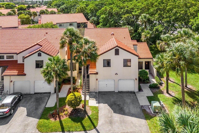 10 Via De Casas Sur Unit 104, Boynton Beach, FL 33426 - mediterranean / spanish-style house featuring an attached garage, driveway, stairway, and a tile roof
