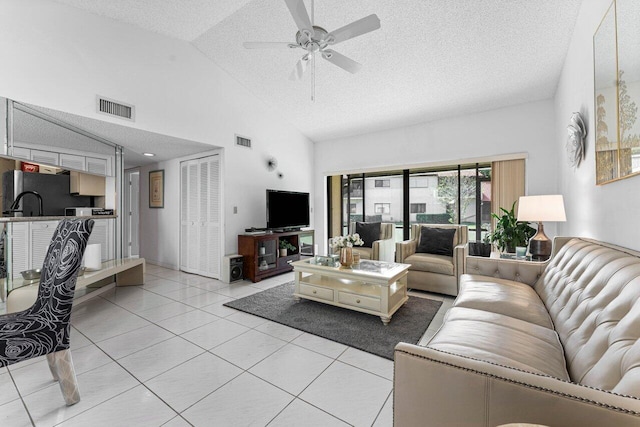 tiled living room with high vaulted ceiling, a textured ceiling, and ceiling fan