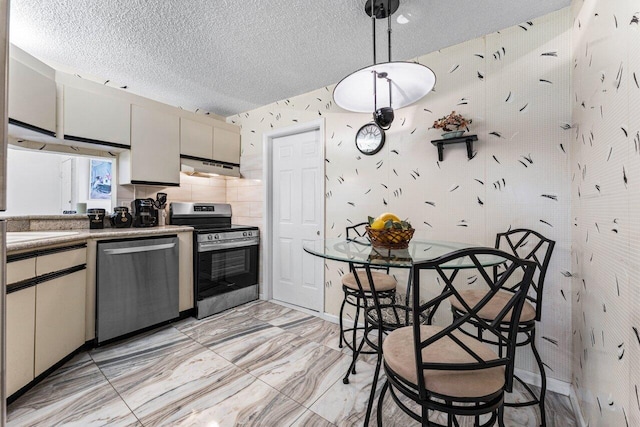 kitchen featuring decorative backsplash, a textured ceiling, decorative light fixtures, and appliances with stainless steel finishes