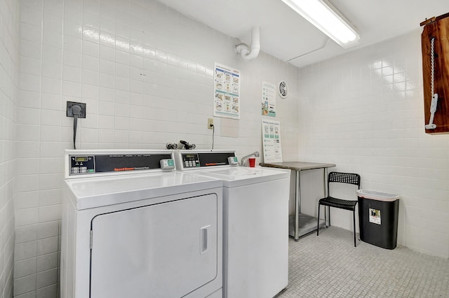 washroom with tile walls and independent washer and dryer