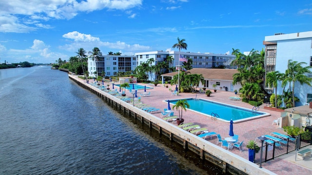 view of swimming pool with a water view and a patio area