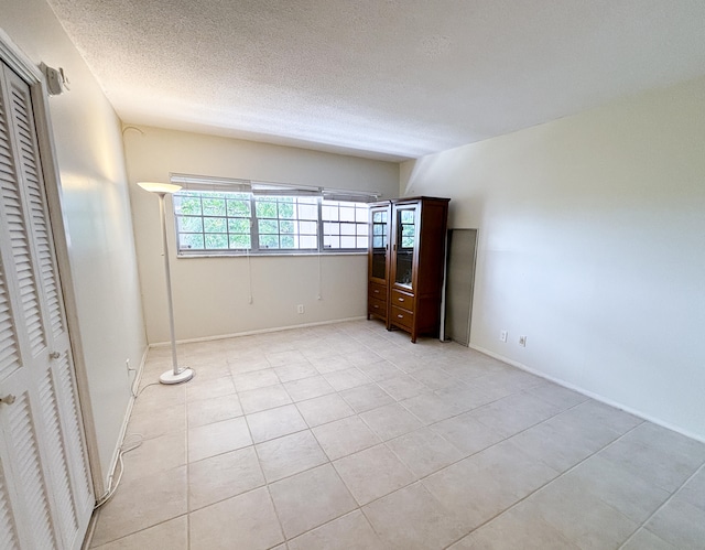 unfurnished bedroom with a textured ceiling and light tile patterned floors