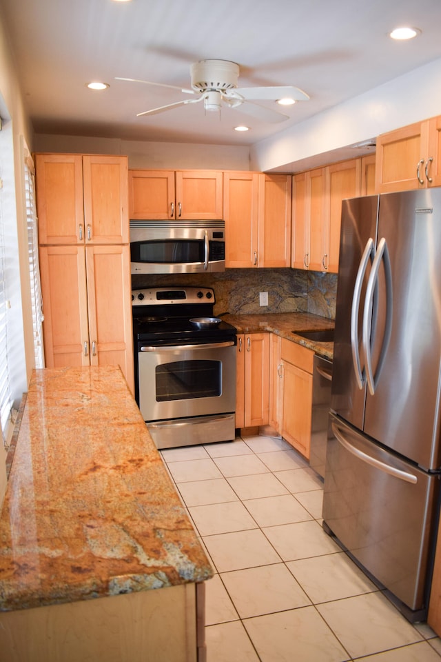 kitchen with appliances with stainless steel finishes, light brown cabinetry, light stone countertops, and ceiling fan