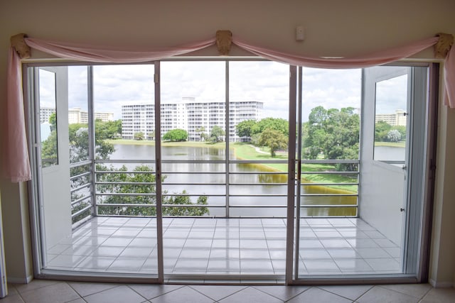 doorway to outside with light tile patterned floors and a water view