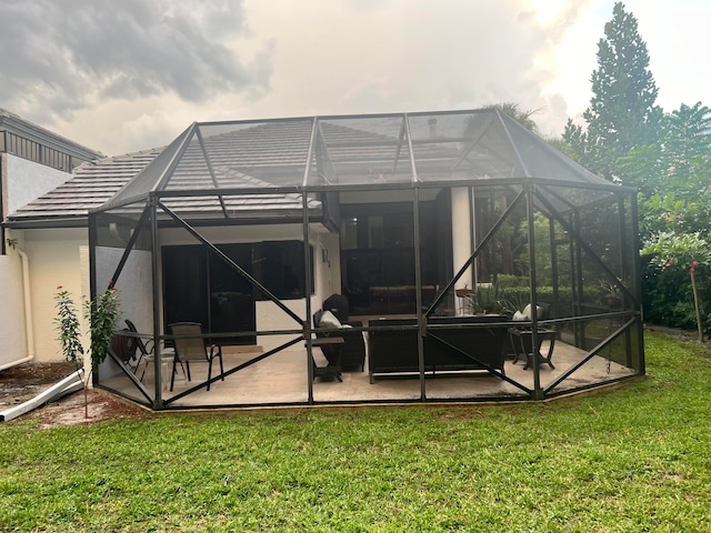 back of house with a patio, a yard, and glass enclosure