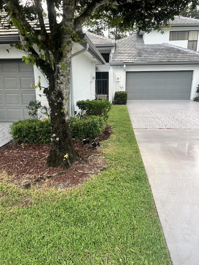 1120 Sand Drift Way Unit A, West Palm Beach, FL 33411 - view of front of home featuring stucco siding, driveway, an attached garage, and a tiled roof