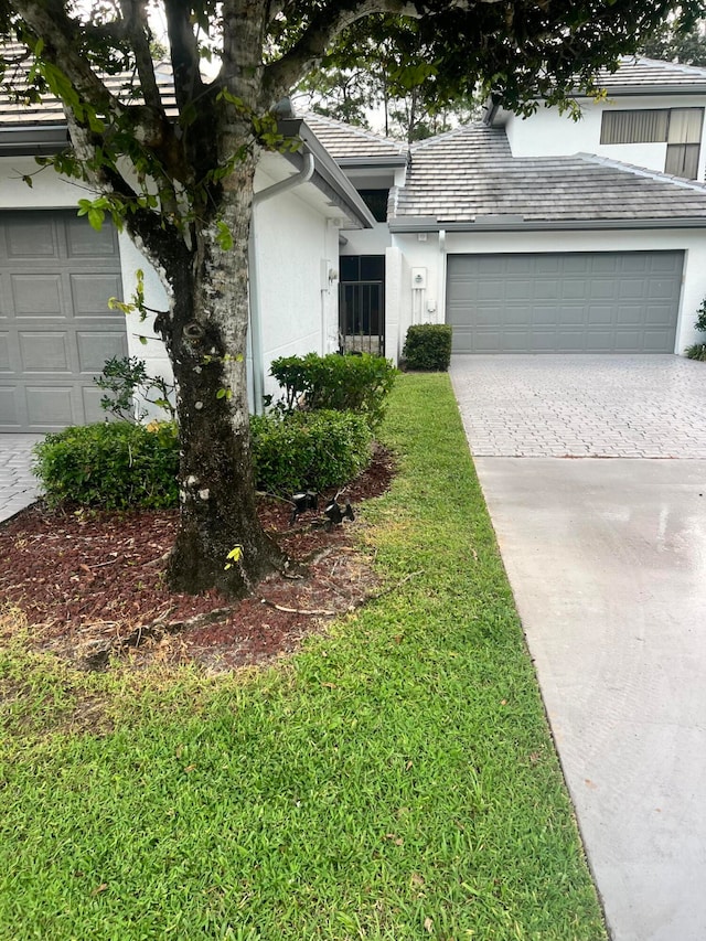 view of front of property with a garage and a front lawn