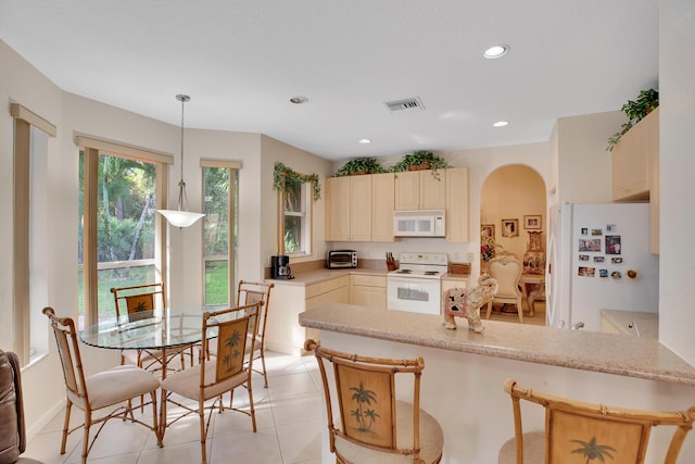 kitchen featuring cream cabinetry, white appliances, decorative light fixtures, kitchen peninsula, and light tile patterned flooring