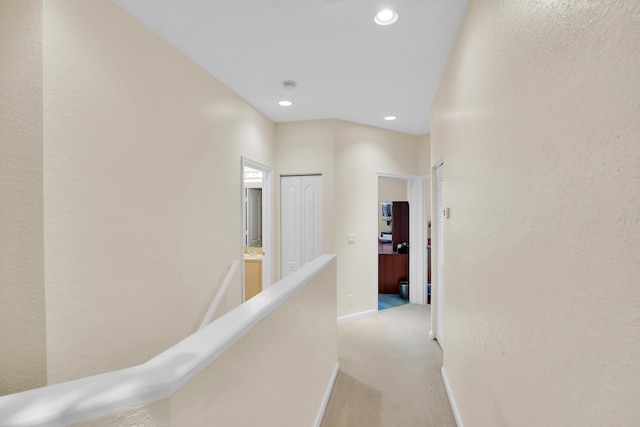 hall with light colored carpet