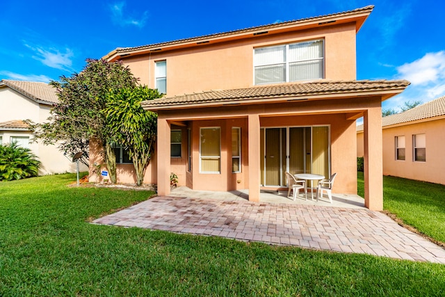 rear view of property with a yard and a patio area