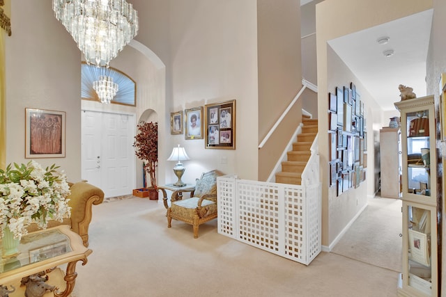 carpeted entrance foyer featuring an inviting chandelier and a high ceiling