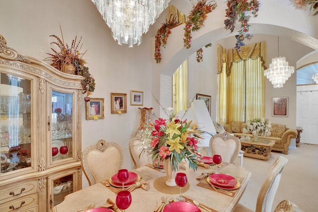 dining area featuring a towering ceiling and a chandelier