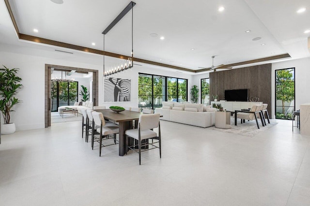 dining area with a raised ceiling and ceiling fan