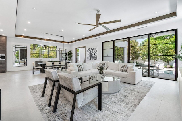 living room featuring a raised ceiling and ceiling fan