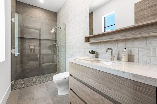 bathroom featuring walk in shower, toilet, decorative backsplash, vanity, and tile walls