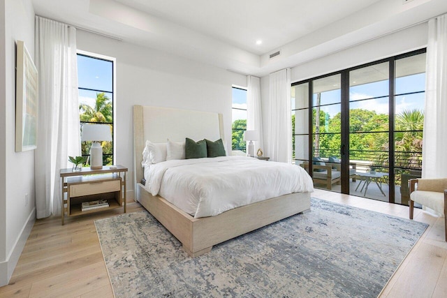 bedroom with access to exterior and light wood-type flooring