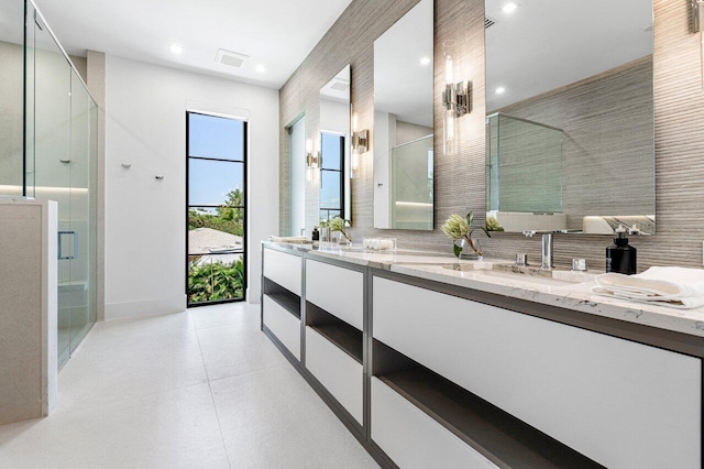 bathroom with vanity, backsplash, walk in shower, and tile walls