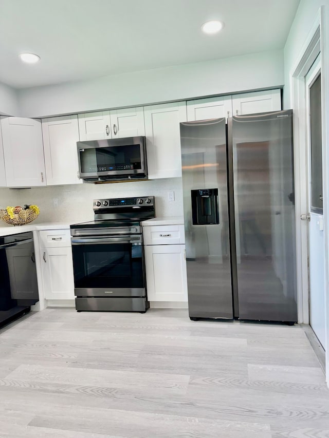 kitchen featuring stainless steel appliances, light wood-type flooring, and white cabinetry