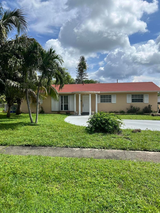 single story home featuring a front lawn