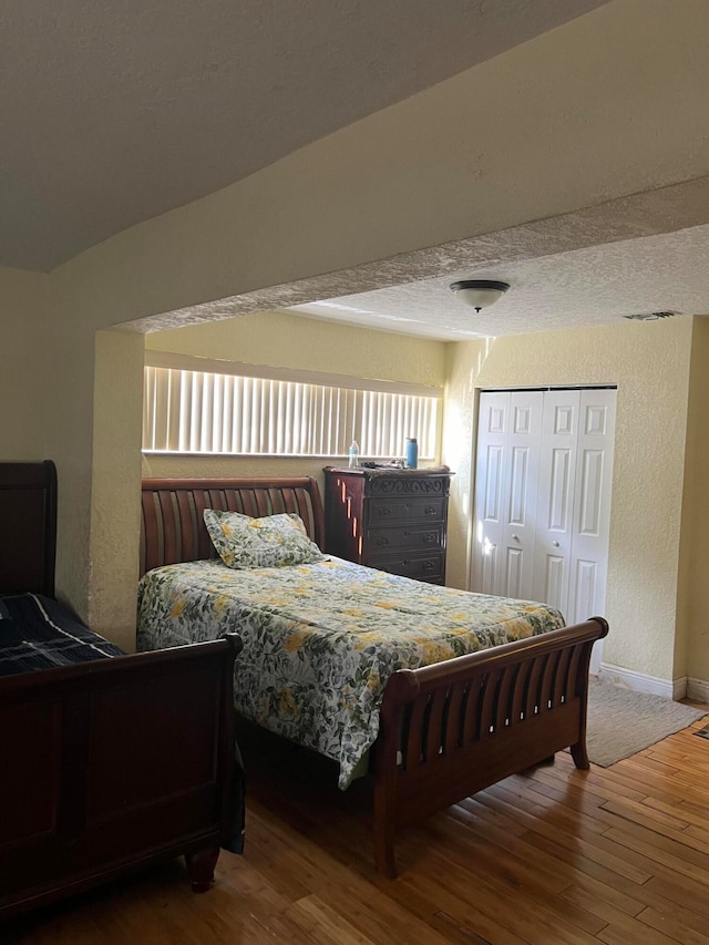 bedroom featuring a textured ceiling, a closet, and hardwood / wood-style flooring