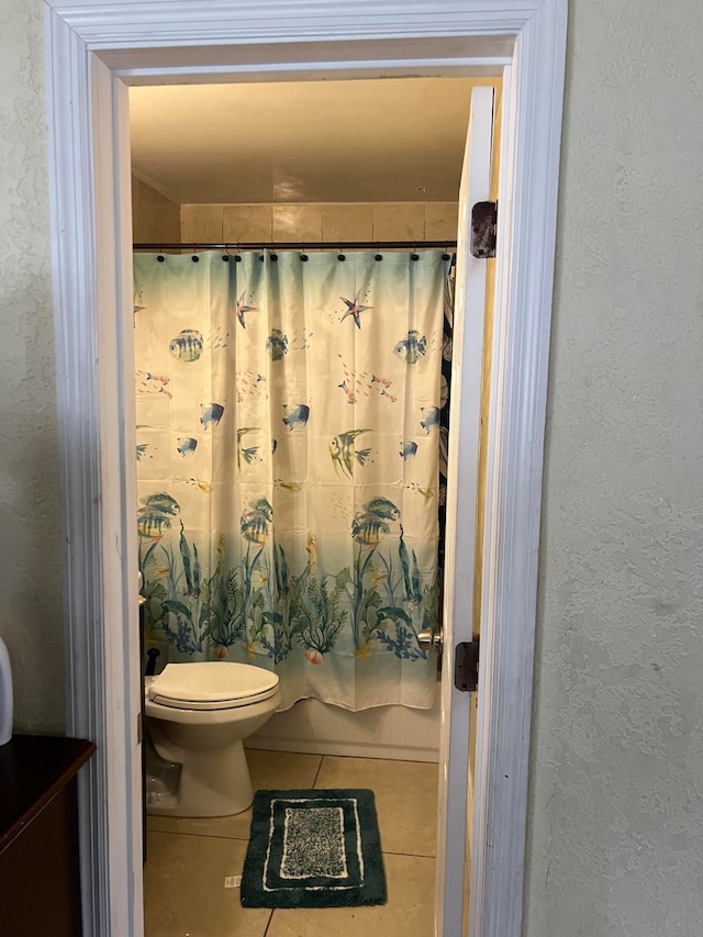 bathroom with tile patterned flooring, toilet, and shower / tub combo