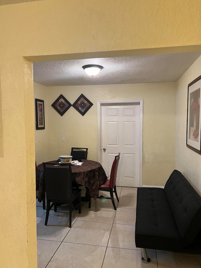 tiled dining space with a textured ceiling