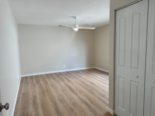 unfurnished room featuring ceiling fan, a textured ceiling, and light hardwood / wood-style flooring