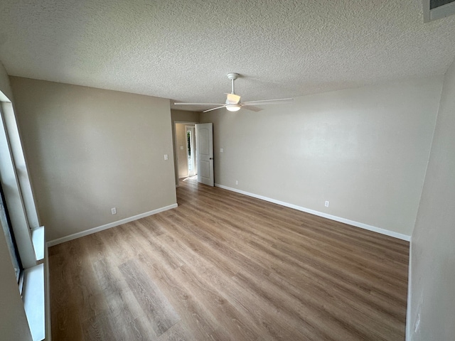 empty room with a textured ceiling, light hardwood / wood-style flooring, and ceiling fan